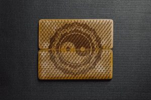 Yin Yang symbol etched on a wooden bed of nails with a dark textured background.
